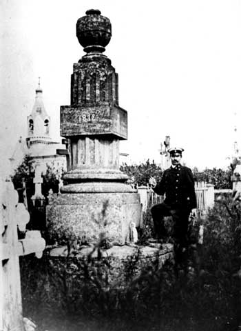Из-за могильного памятника видна колокольня Смоленско-Богородицкой кладбищенской церкви